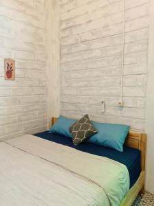 卡里蒙贾瓦KALINDA HOMEY的卧室内的一张带蓝色枕头的床
