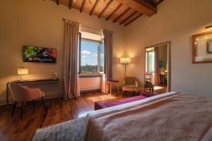 埃尔萨谷口村黎莱斯德拉罗维雷酒店的一间卧室配有一张床、一张书桌和一个窗户。