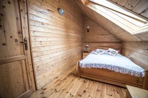 SpytkowiceApartamenty na Kasztelańskiej的木制客房内的一间卧室,配有一张床