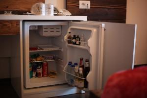 GjakoveHotel Happy的配有食品和饮料的开放式冰箱