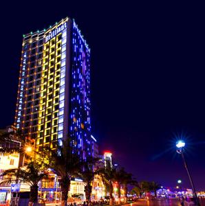 岘港辉煌酒店的一座高大的建筑,晚上有蓝色的灯光