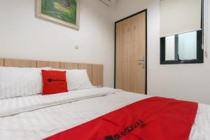 雅加达RedDoorz near Seasons City Mall 3的一间卧室配有一张红色枕头的床