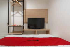 雅加达RedDoorz near Seasons City Mall 3的一间卧室设有一张带平面电视的床。
