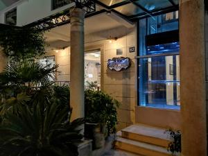 布德瓦佩拉迪玛尔酒店的一座带楼梯和植物的建筑的前门