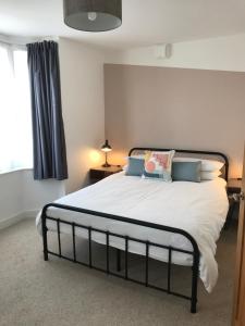 布莱顿霍夫Kemp Town Sea View Balcony Apartment的一间卧室配有一张带白色床单的床和一扇窗户。