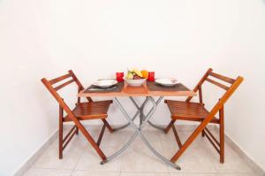 卡尔帕索斯Iris Studios的一张桌子,上面有两把椅子和一碗水果
