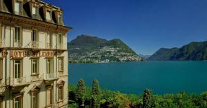 卢加诺斯普莱迪德皇家酒店的享有湖泊和山脉景色的建筑