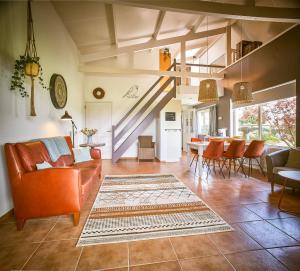 MoorveldVakantiewoning Cha Nostra的一间带橙色家具的客厅和一间餐厅