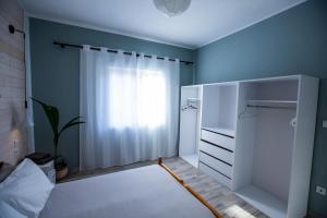 纳弗帕克托斯Nafpaktos Family Apartment 2的一间拥有蓝色墙壁的卧室、一张床和窗户