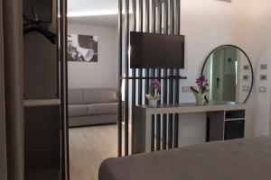 里米尼拉格拉迪斯卡酒店的一间卧室配有一张床、镜子和一张沙发