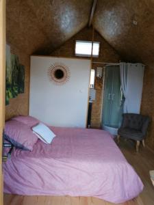 热莫扎克Le petit Radieux的卧室配有粉红色的床和椅子