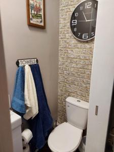 斯卡伯勒Trafalgar Retreat的一间带卫生间和墙上时钟的浴室