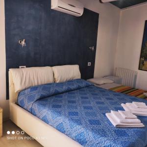 夸尔图-圣埃莱娜Antico Centro Quartu B&B的一间卧室配有蓝色的床和毛巾