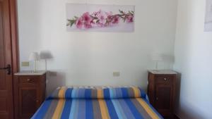 斯特龙博利Agriturismo SoleMare的一间卧室配有床和2个梳妆台,并拥有粉红色的鲜花