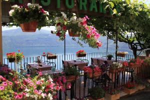 冈多菲堡卡斯特甘多夫酒店的餐厅设有鲜花桌,享有水景