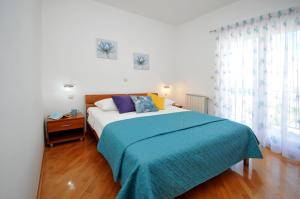 特罗吉尔Apartments Roza的一间卧室配有一张带蓝色毯子的大床
