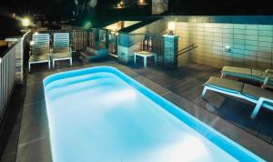 艾因萨Hotel Dos Rios Origen的夜间游泳池,配有椅子和桌子