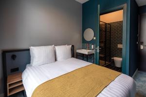 鹿特丹FD Hotels的一间带大床的卧室和一间浴室