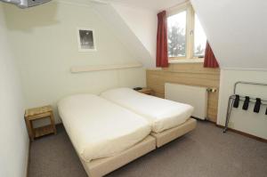 KaardHotel De Horper Wielen的卧室配有白色的床