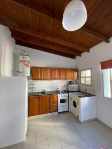布兰卡港巴伊亚公寓的厨房配有木制橱柜和白色的电器