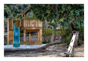 艾克索斯伊纳格恩生态旅游村酒店的一个带滑梯和树的木制游乐场