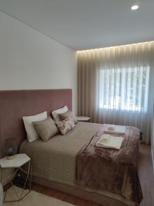 波尔图Suite na baixa do Porto的一间卧室设有一张大床和一个窗户。