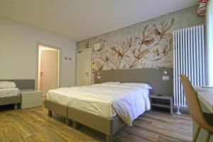 罗卡皮耶托雷Hotel Venezia的卧室配有一张床,墙上挂有绘画作品