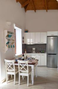 哈尔基岛Aegean View Villas的厨房配有桌椅和冰箱。