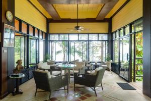 蔻立Baan Krating Khao Lak Resort - SHA plus的客厅配有桌椅和窗户。