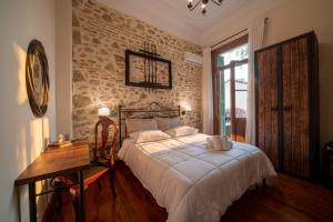 雅典Beautiful City Suites的一间卧室设有一张床和砖墙
