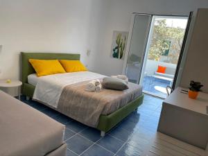 加利波利ITINERA Baia Verde Rooms and Breakfast的一间卧室配有黄色和橙色枕头的床