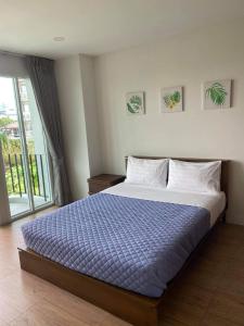 曼谷TEAK VILLA的一间卧室配有一张带蓝色棉被的大床
