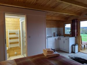 坎特伯雷Foxhill Lodges的一间设有厨房和一张位于房子内的床铺的房间