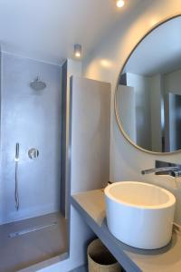 巴特斯欧Iliades Luxury Boutique Suites的一间带大型圆形水槽和镜子的浴室