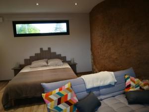 MarchésieuxTerre des marais的一间卧室配有一张床、一张沙发和一个窗口