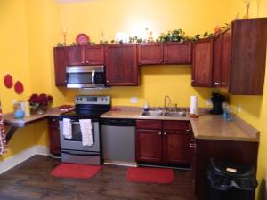 萨凡纳Marie@305的厨房配有木制橱柜、炉灶和水槽。