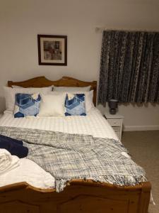 Holcot Cottage的一间卧室配有一张带蓝色和白色枕头的床