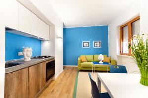 奥特朗托Appartamenti fronte mare Otranto的厨房拥有蓝色的墙壁,配有桌子和沙发