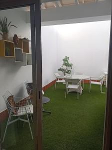 维辛达里奥Habitación Privada May的客房配有桌椅和绿色地毯。