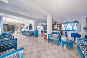 埃夫迪洛斯阿瑟拉酒店的一间设有蓝色椅子和桌子的等候室