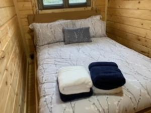 因弗内斯Immaculate cabin 5 mins to Inverness dogs welcome的一张位于小房子里的床铺,上面有蓝色和白色的毯子