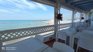 加利波利Ventidimaregallipoli的阳台配有白色椅子,享有海滩美景