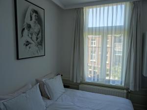 海牙艾玛住宿加早餐旅馆的一间卧室设有一张床和一个大窗户
