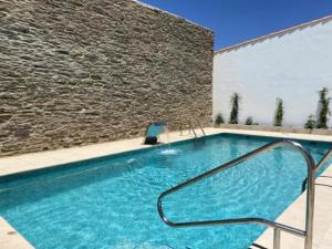 La CodoseraLa Casa Grande de Adolfo的一座大型游泳池,毗邻石墙