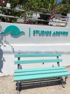 波罗斯Studios Argyris的蓝长凳坐在标志前