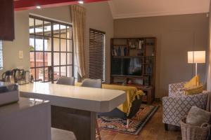 德尔斯特鲁姆Camdeboo Place的厨房以及带沙发和桌子的客厅。