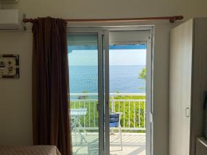 萨莫色雷斯Samothraki Akrogiali Rooms的客房设有滑动玻璃门,享有海景。