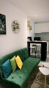 奥尔良Maisonnette en hyper centre d’Orléans的客厅设有绿色沙发,配有厨房