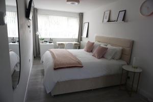 贝尔法斯特Amica Guesthouse的卧室配有一张带粉红色枕头的大床