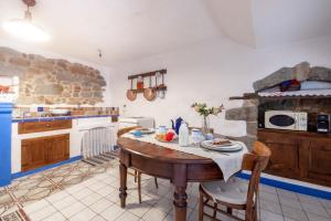 丰尼Casa Masini的一间带木桌的厨房和一间带炉灶的厨房